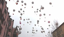 Luftballons steigen am Hundertwasserhaus in den Himmel.