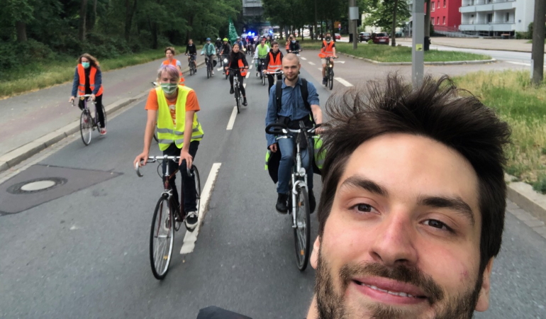 Im Vordergrund ist Urs Liebau auf dem Fahrrad zu sehen. Im Hintergrund befinden sic Jugendliche auf Fahrrädern