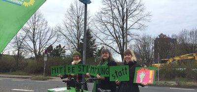 Grüne Frauen stehen unterm Straßenschild Kritzmannstraße/Mechthildstraße und halten Schild - Mitbestimmung.