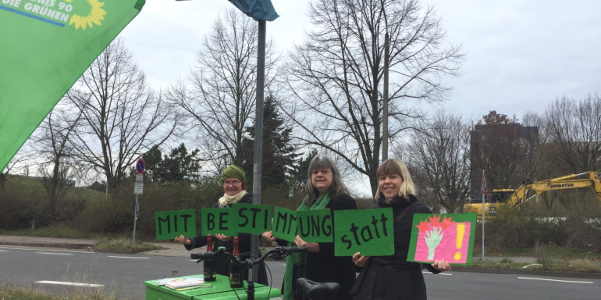 Grüne Frauen stehen unterm Straßenschild Kritzmannstraße/Mechthildstraße und halten Schild - Mitbestimmung.