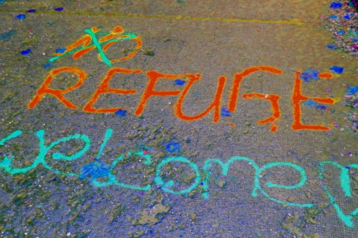 Sprühspruch auf dem Boden "No Refuge" korrigiert zu "Reguge welcome".