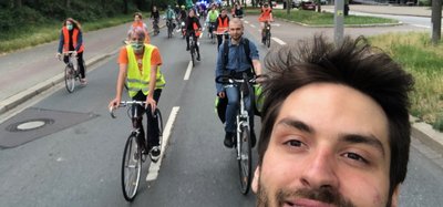 Im Vordergrund ist Urs Liebau auf dem Fahrrad zu sehen. Im Hintergrund befinden sic Jugendliche auf Fahrrädern