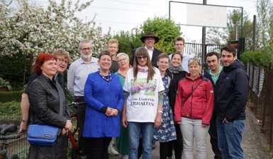 Gruppenbild mit Kleingärtnern, Ministerin Claudia Dalbert und grünen Mitgliedern am Eingang der Kleingartensparte Am Unterbär.