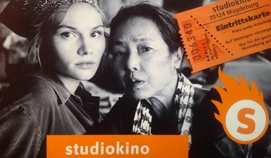 Bild aus dem Film "Grüße aus Fukushima" mit den beiden Hauptdarstellern und einer Kinokarte.