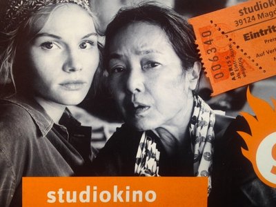 Bild aus dem Film "Grüße aus Fukushima" mit den beiden Hauptdarstellern und einer Kinokarte.
