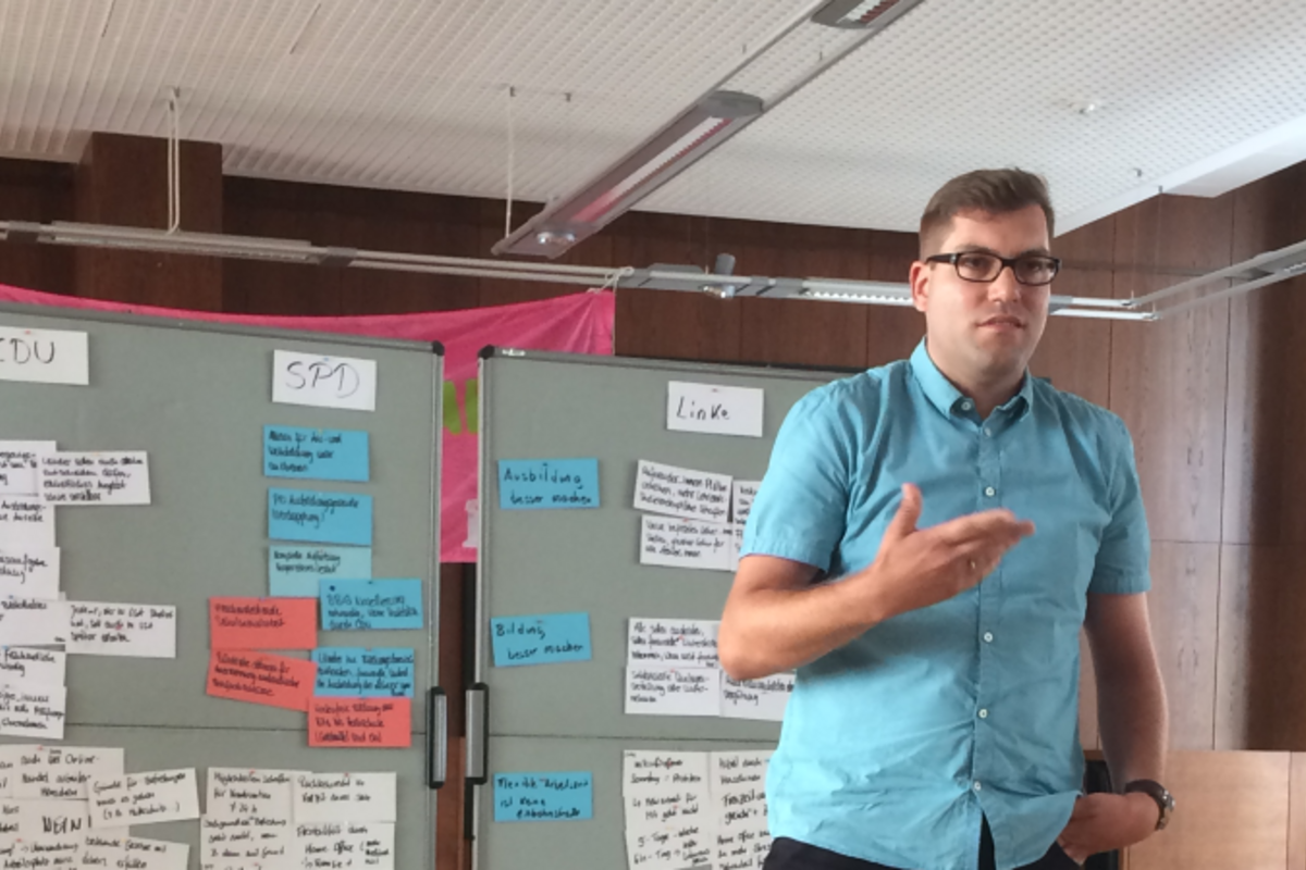 Matthias Borowiak steht vor zwei Flipcharts.