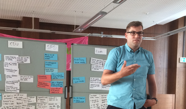 Matthias Borowiak steht vor zwei Flipcharts.