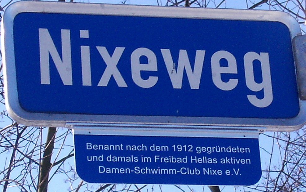 Straßenschild am Nixeweg mit dem Zusatz: Benannt nach dem 1912 gegründeten und damals im Freibad Hellas aktiven Dámen-Schwimm-Club Nixe e. V.