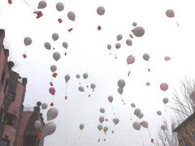 Luftballons steigen am Hundertwasserhaus in den Himmel. 