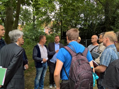 Gesprächsgruppe vor Bäumen am Turmpark.