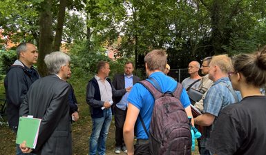 Gesprächsgruppe vor Bäumen am Turmpark.