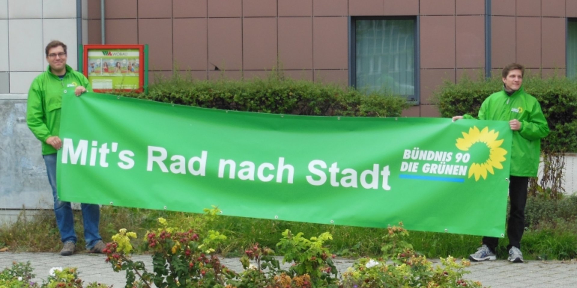 Mit's Rad nach Stadt - Grünes Banner am Uniplatz.