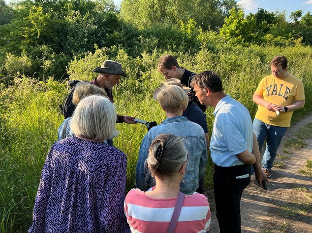 Die Wandergruppe schaut sich gemeinsam etwas an, was Ernst-Paul Dörfler ihnen zeigt.