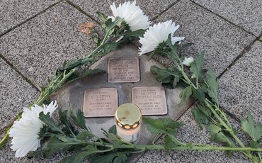 Geputze Stolpersteine von Marta Maria und Leo Stern sowie von Siegbert Hammelburger., geschmückt mit Bl