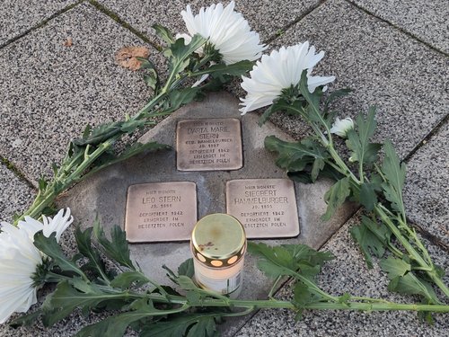 Geputze Stolpersteine von Marta Maria und Leo Stern sowie von Siegbert Hammelburger., geschmückt mit Bl