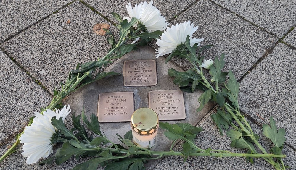 Geputze Stolpersteine von Marta Maria und Leo Stern sowie von Siegbert Hammelburger., geschmückt mit Bl